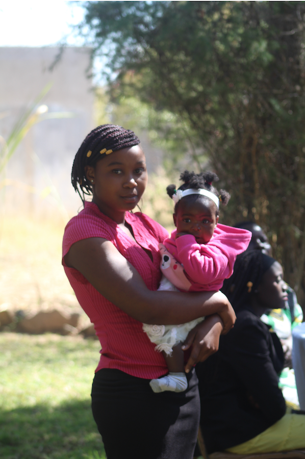 Ruth Musarurwa poses holding her baby, Seke teen mother