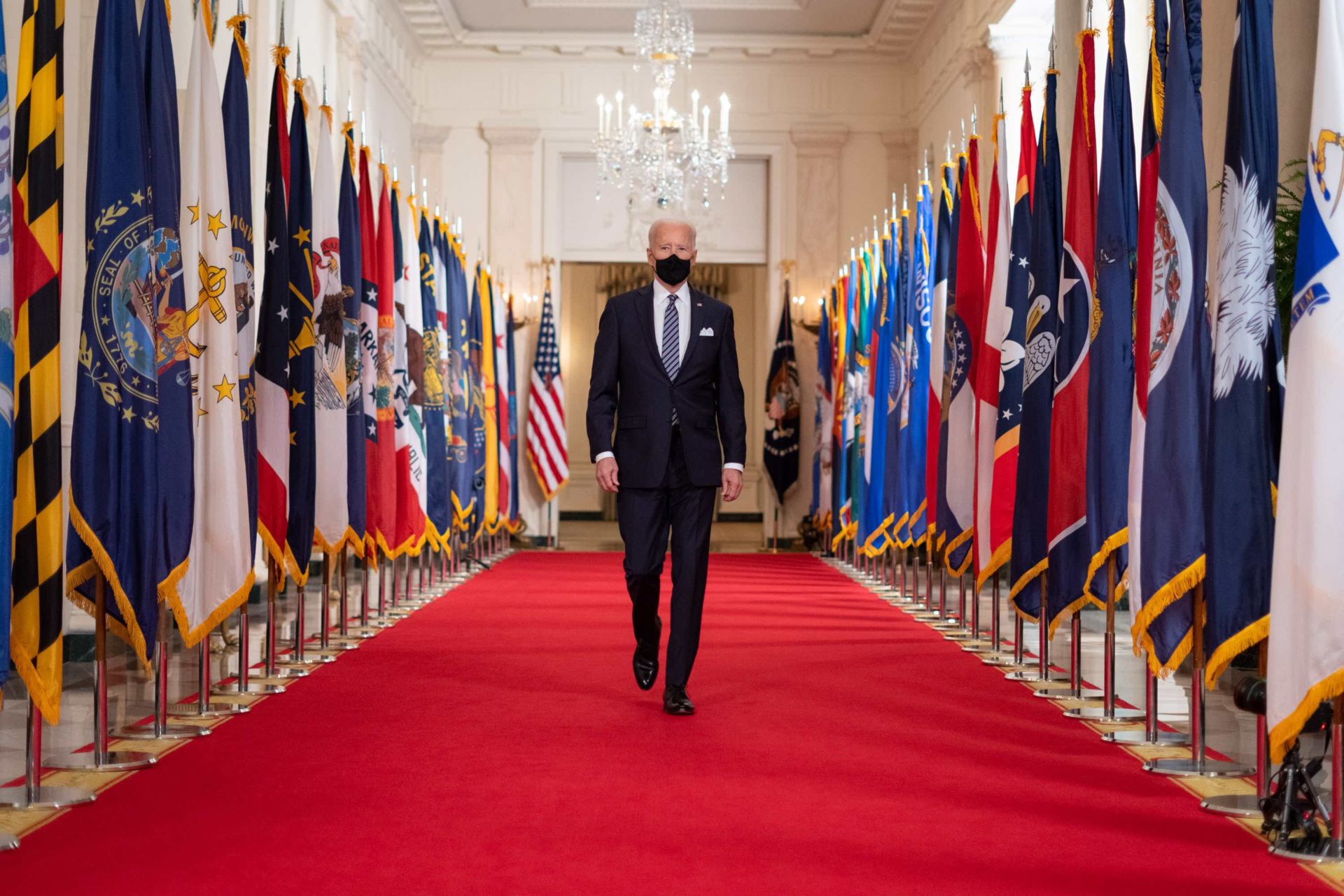 President Joe Biden walks from the State Dining Room of the White House to a podium in the Cross Hall of the White House Thursday, March 11, 2021, to deliver remarks on the one year anniversary of the COVID-19 Shutdown. (Official White House Photo by Adam Schultz)