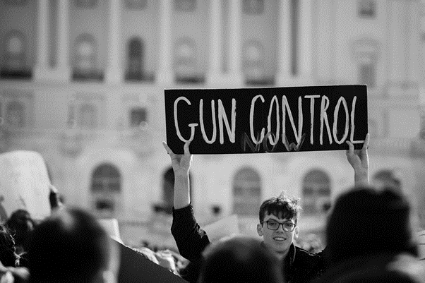 In This Photo: “Gun Control Now.” A student participating in National Walkout Day at the Capitol, Washington DC. Photo Credits: Flickr