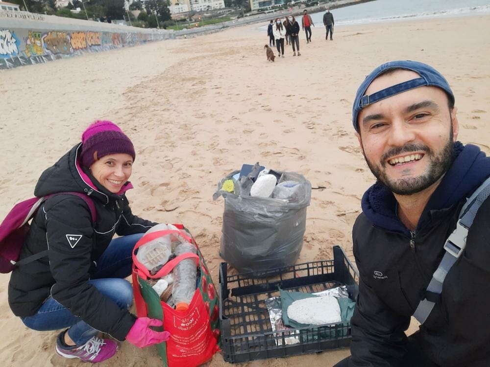 Alexandre with volunteers cleaning up a beach from plastic.