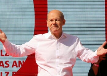 man on stage opening arms