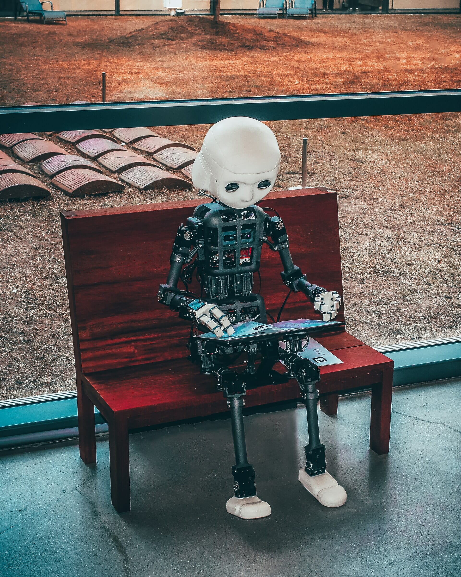 Robot reading his book on a bench
