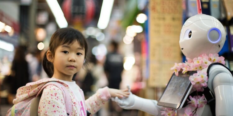 girl holding the hand of a robot