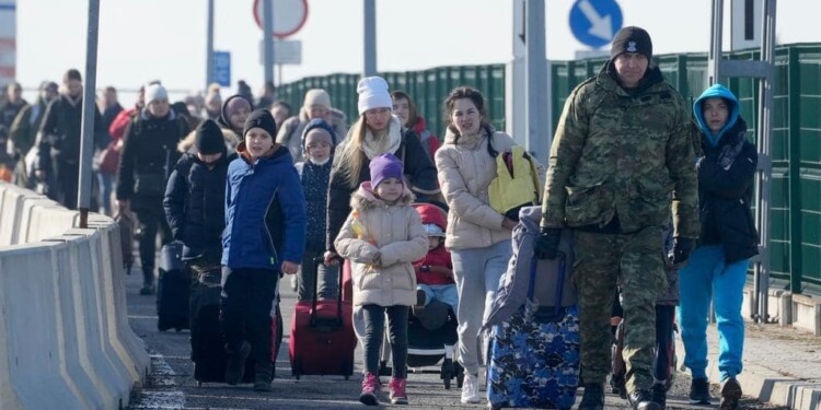 In the Photo: Ukrainian refugees from March 2022, crossing into Poland
Photo Credit: Wikimedia Commons