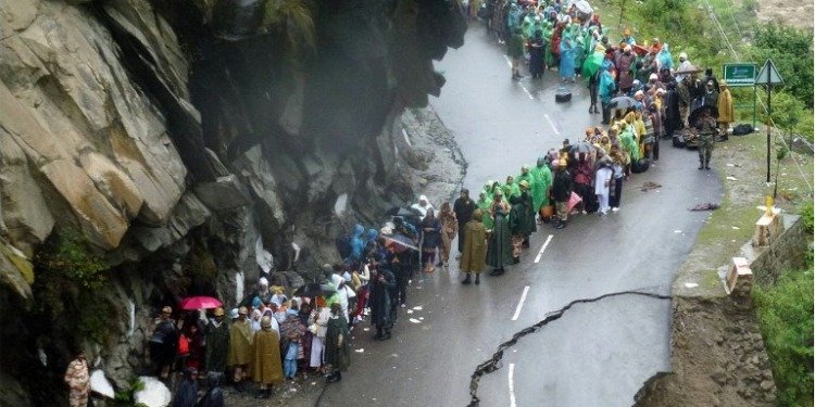 Indian Army supervises residents as they stand on the remains of a flood destroyed road alongside the River Alaknanda in the northern Indian state of Uttarakhand in 2013.