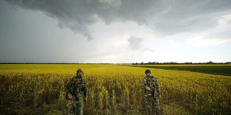 Russian soldiers guard an area next to a field of wheat in Ukraine on June 14, 2022.