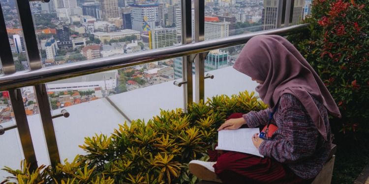 Vertical Villages: A girl sits and reads above Jakarta's skyline