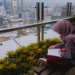 Vertical Villages: A girl sits and reads above Jakarta's skyline