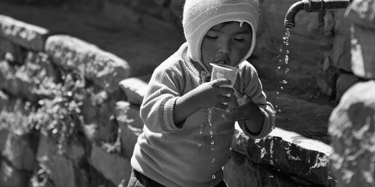 In the Photo. Young Child Drinking Water in Peru.