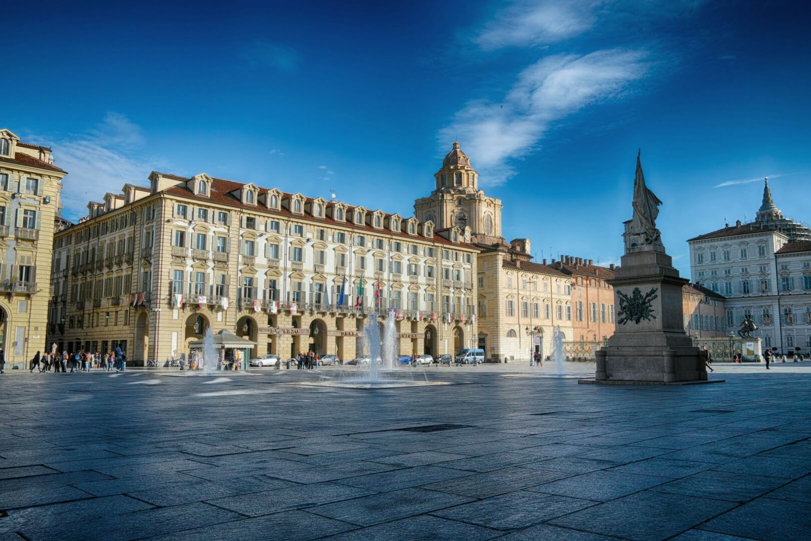 The sun shines on a historic building in a plaza in Turin. 