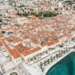 White buildings with orange roofs sit alongside the coast in Split, Croatia.