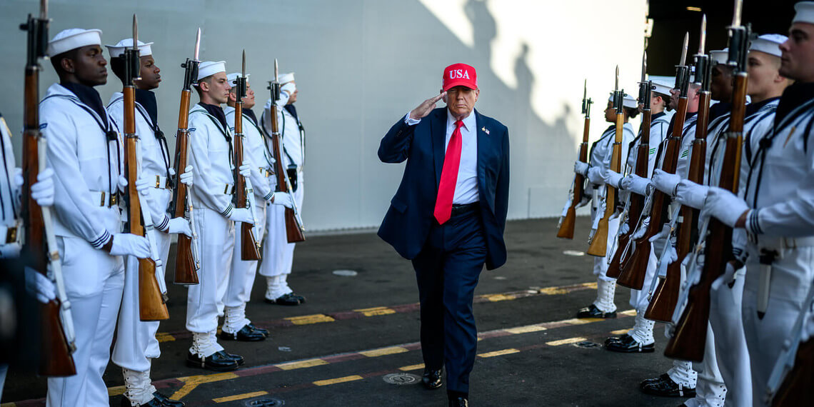 US President Donald Trump salutes sailors as he walks toward the stage to deliver remarks in honor of the U.S. Navy 250th anniversary celebration at the USS Harry S. Truman aircraft carrier at Naval Station Norfolk in Norfolk, Virginia, Oct. 5, 2025.