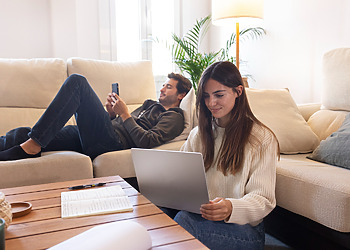 Couple in their living room, dealing with their home internet connection.