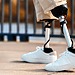 View of a walking man with prosthetic legs and white sneakers frimufilms