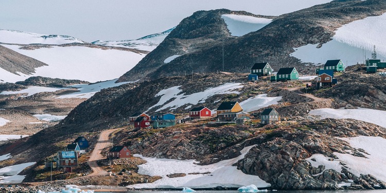 Houses sit on the coast of Greenland.