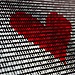 A red heart composed of binary code