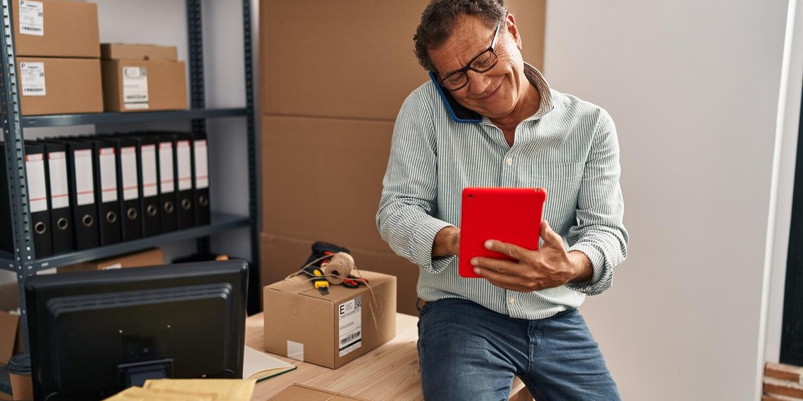 An Amazon Seller dealing with his accounts on a red tablet.