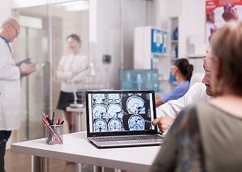 Doctor shows a patient a CT scan for a brain injury case legal consultation