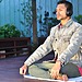 A man sitting on his yoga mat, managing stress through meditation.