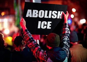 Protestor holding "Abolish ICE" banner