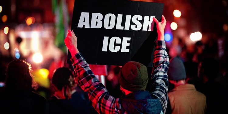 Protestor holding "Abolish ICE" banner