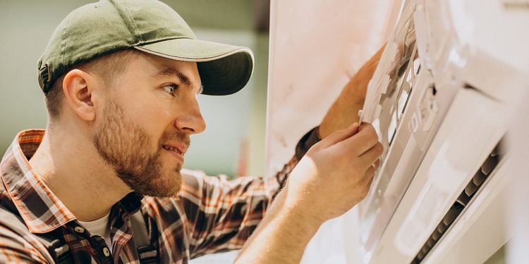 AC Repair Companies: a service man at work on a AC unit.
