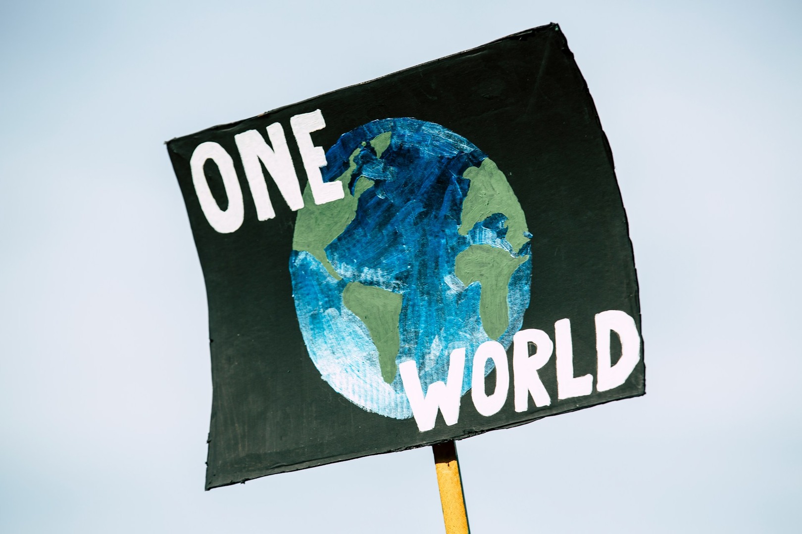 A protest sign stating "one world"