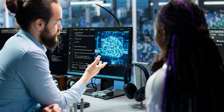 A woman and a man from the IT team working with the support of an AI agent.