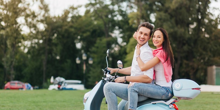 couple riding a Vespa