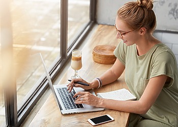 Woman on her laptop at a window