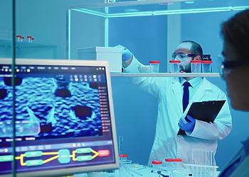 wo laboratory researchers analyzing medical imaging data on a clinical computer screen showcasing custom AI healthcare software solutions.