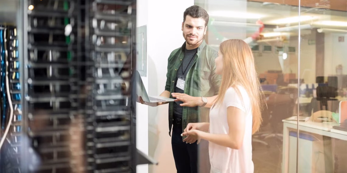 Engineer and assistant in front of a row of High-Performance Hosting servers.