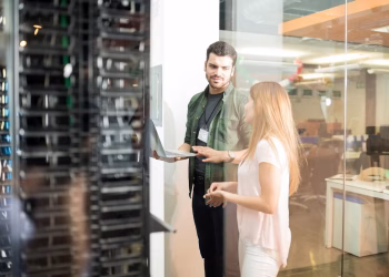 Engineer and assistant in front of a row of High-Performance Hosting servers.