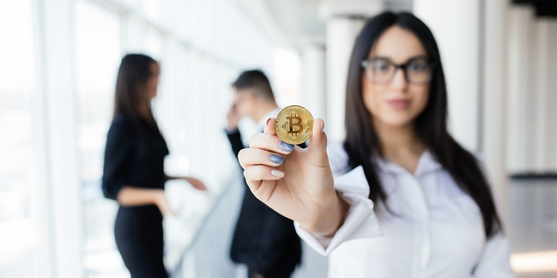 Woman showing a physical bitcoin.