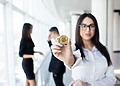 Woman showing a physical bitcoin.