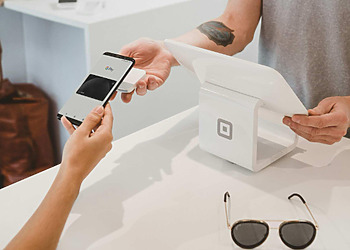 Women paying at a POS with her phone