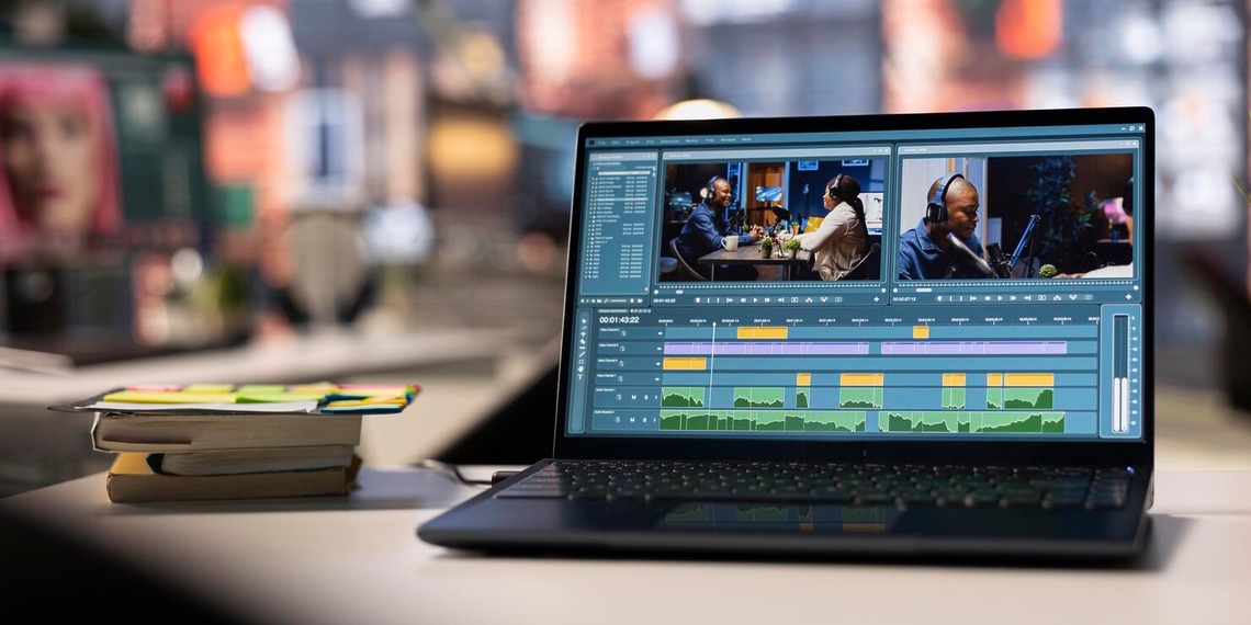 Professional video editor working with multiple screens to analyze and edit digital video content.