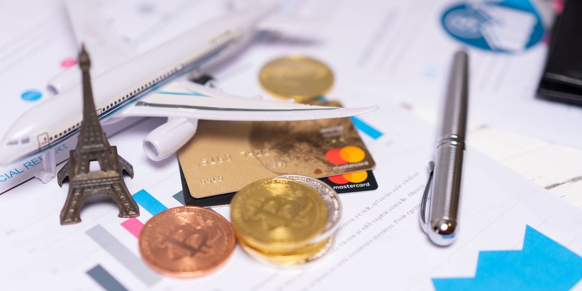 International investment planning documents with foreign currency, payment cards, and travel symbols representing cross-border tax planning and global holdings.