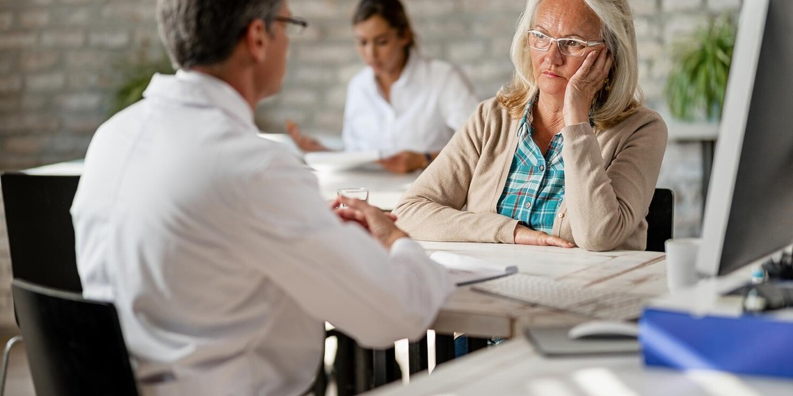 Doctor consulting with an older female patient during a medical appointment about her treatment and health concerns.