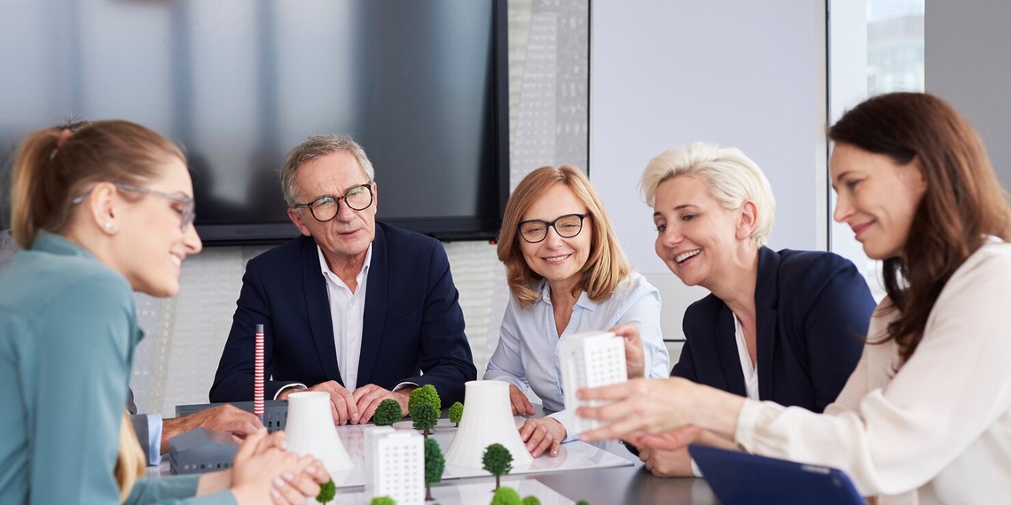 Business leaders discussing sustainable business growth, ESG strategy, and funding opportunities during a planning meeting.