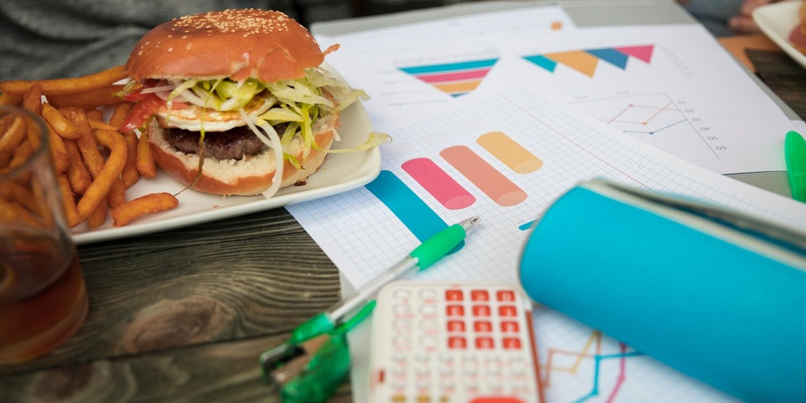 Fast food meal and restaurant branding materials displayed on a table, illustrating customer experience and restaurant growth strategies.