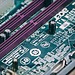 Detailed close-up of a green electronic circuit board with visible components and slots.