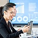 Business professional using a smartphone with digital finance analytics displayed in a modern office