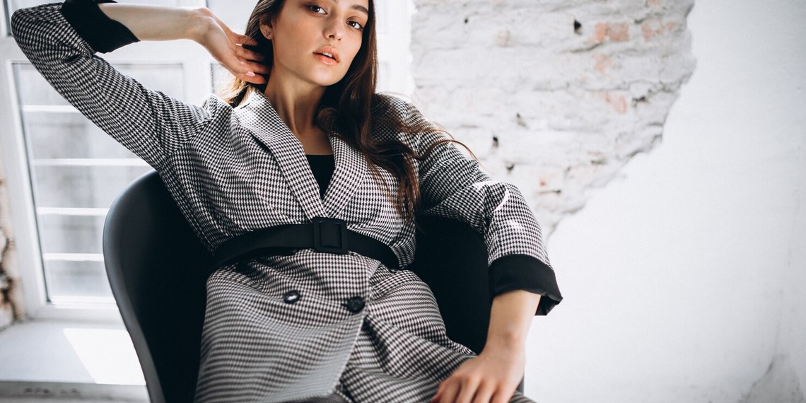 Woman wearing a tailored grey designer suit showcasing timeless women's designer clothing and luxury fashion.