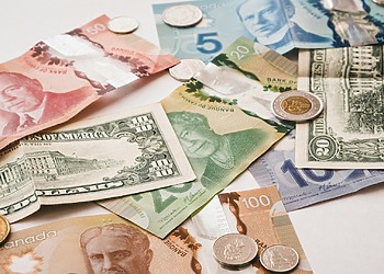 U.S. and Canadian currencies on a white table.