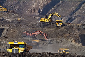 Orange and yellow excavators in a mining area.