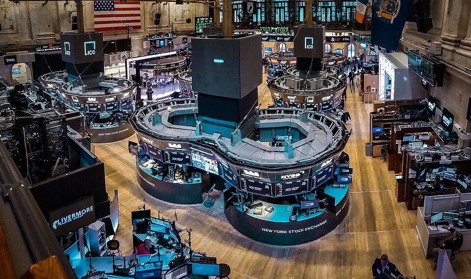 Computer screens give off a blue glow inside the New York Stock Exchange.