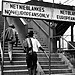 Apartheid sign indicating separate entrances for people categorized as “white” and “non-white” at the entrance to a bridge.