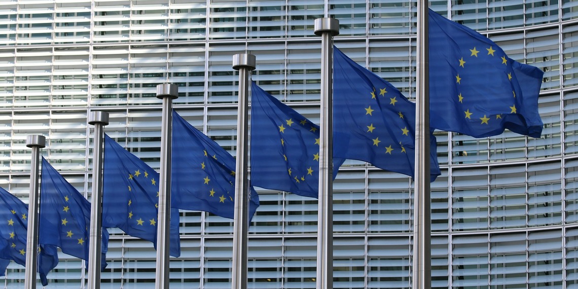 A line of EU flags outside the European Commission Berlaymont building.