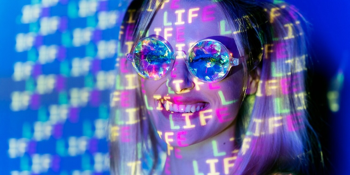 Young woman wearing reflective glasses with digital projections across her face